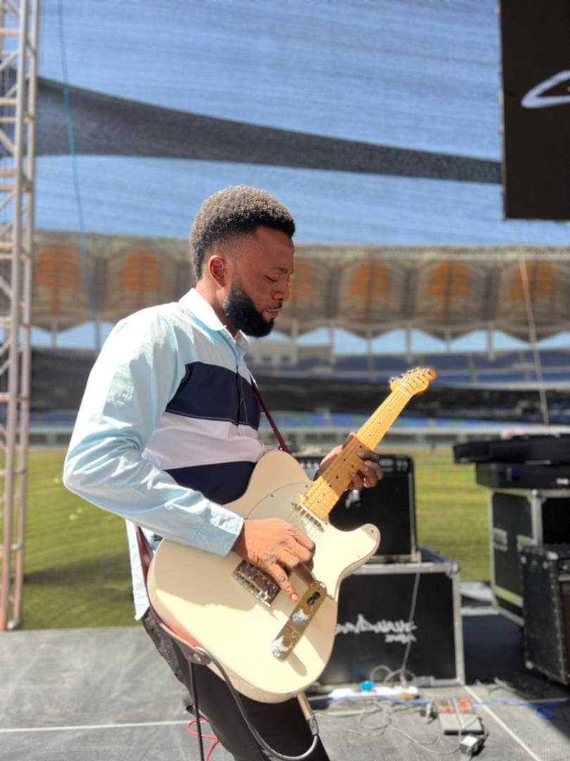Ogunlowo Daniel Segun playing electric guitar on a stadium stage